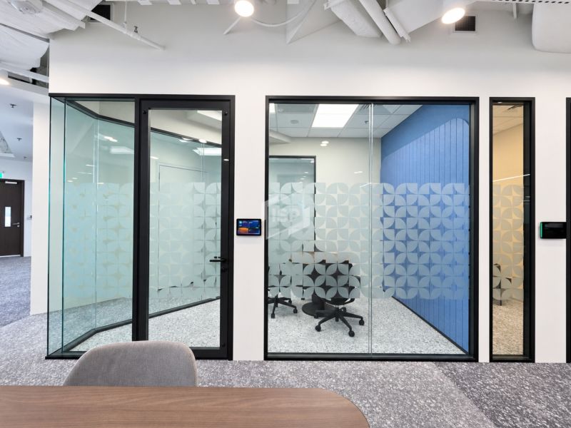 Glass Meeting Room Doors Along Office Corridor
