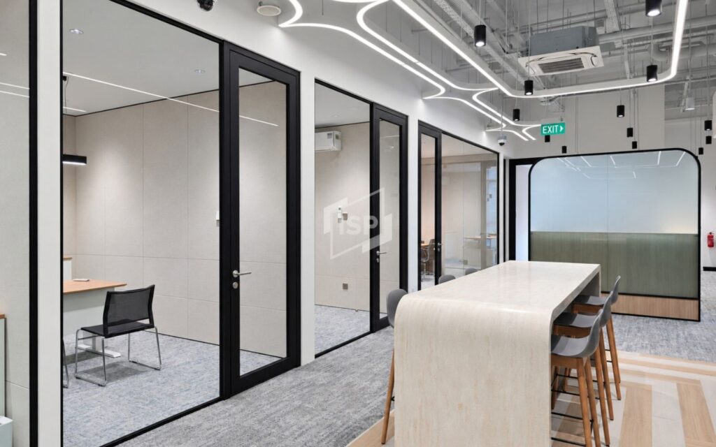 Black-framed glass meeting rooms integrated into a contemporary open-plan office interior