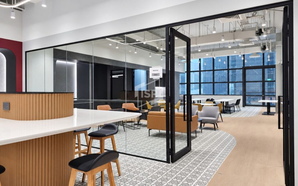 Black-framed glass partition and swing door enclosing a contemporary office collaboration space