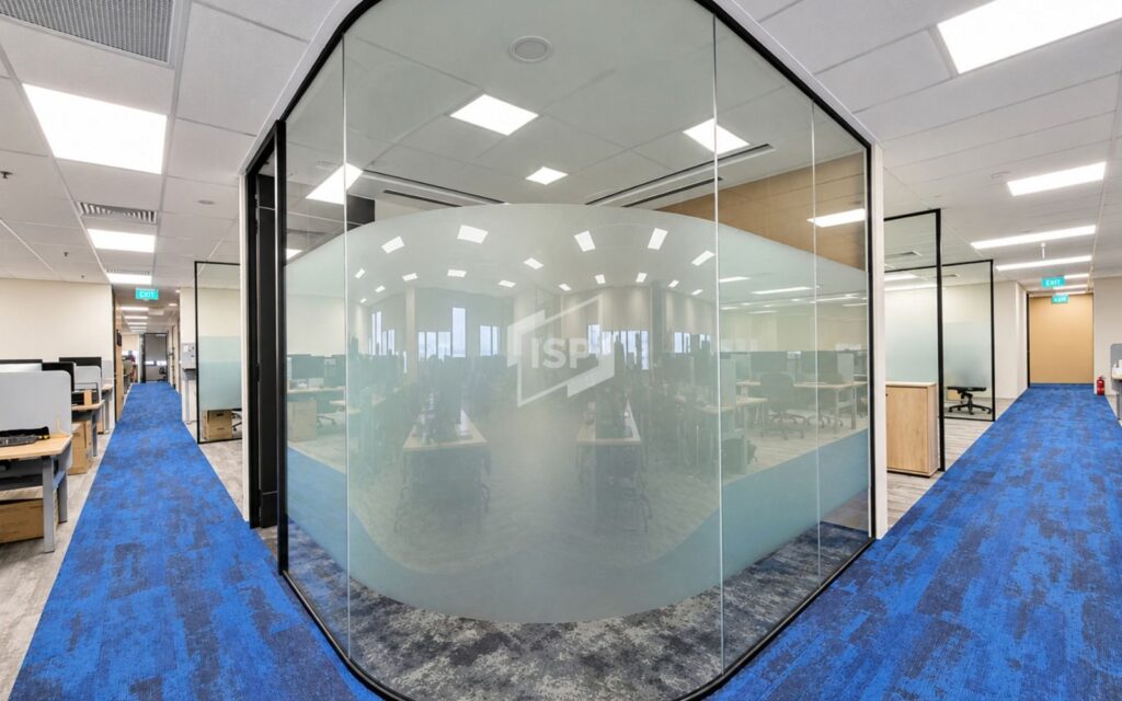 Curved glass partition with frosted privacy film for a modern open-plan office.