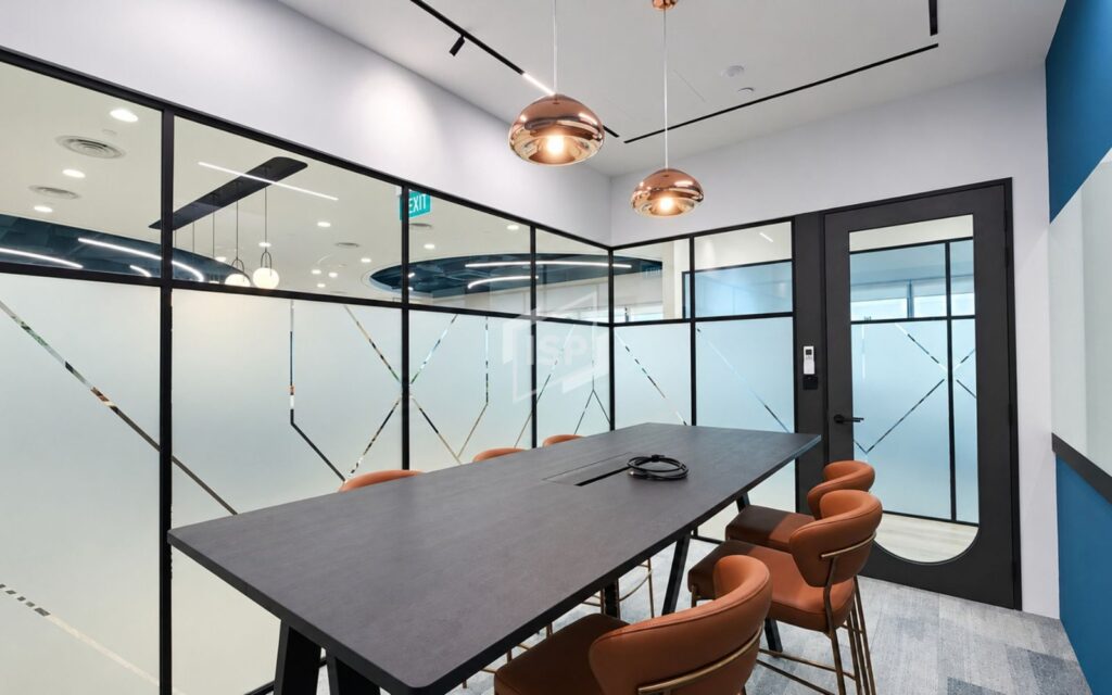 Modern glass meeting room with black frames and geometric frosted privacy decals